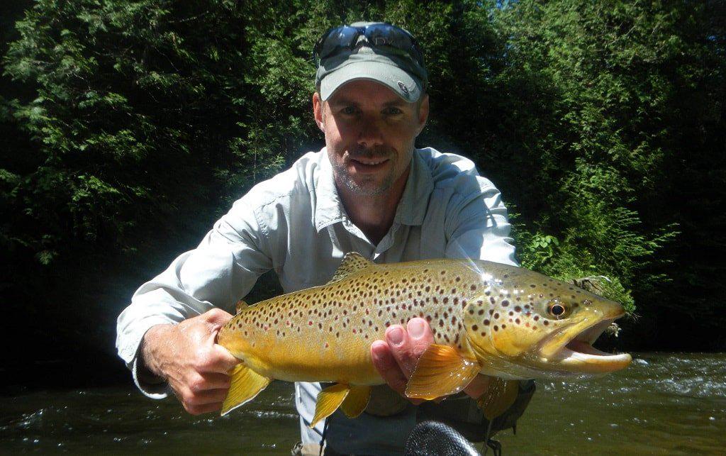 This is Graham who is a trout guide, He is holding a large trout. If you want to learn how to catch trout like this big brown trout, hiring a guide is a good way.