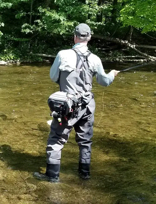 Vest and packs make river fishing easier. An angler with a large simms pack