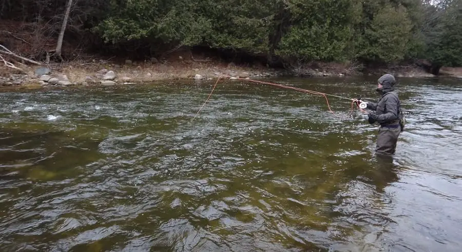 An angler using the right pound test leader for steelhead on a clear river