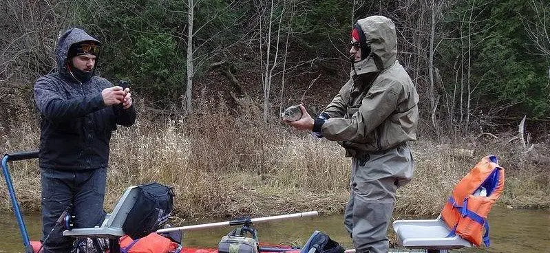 2 anglers enjoying the rewards of trout fishing in the rain.