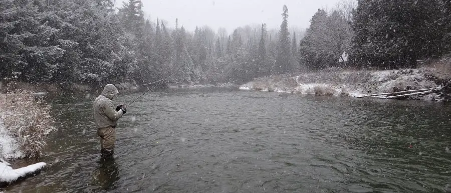 An angler wading in ice cold water