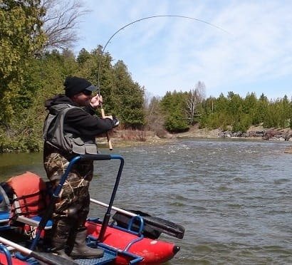 An angler fishing from a river boat