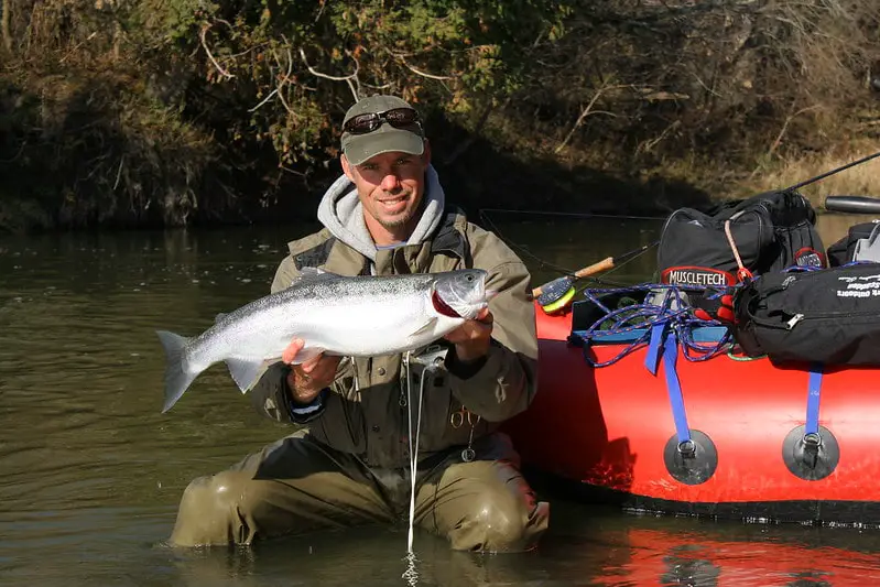 Guide Graham with a nice steelhead, see the float rod and reel behind him.