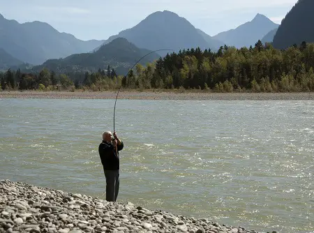 An angler fighting a fish on a large trout, steelhead, and salmon river