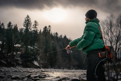 An angler spin fishing for migratory brown trout