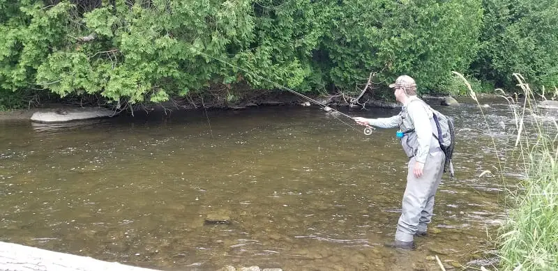 An angler Euro nymphing for trout on shallow water