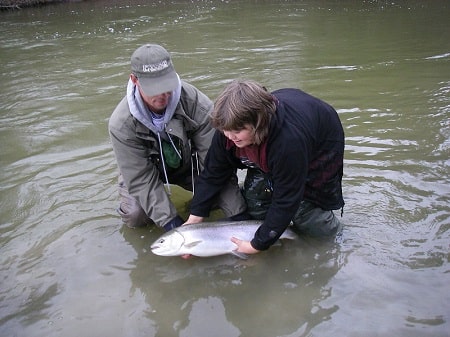 Graham with a young client helping him release a big steelhead