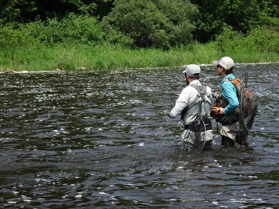 Two competition fly anglers that have their net handle up