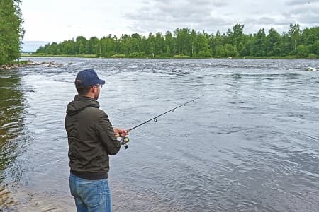 An angler fishing for salmon on a large river.