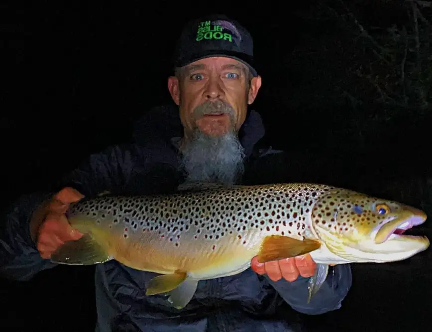 Wild bill with a huge brown trout caught while fly fishing at night.