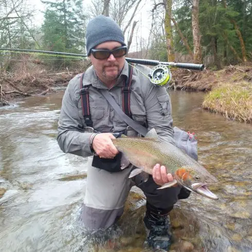 Guide Mike with a nice spring steelhead with his switch reel and rod balancing on his shoulder.