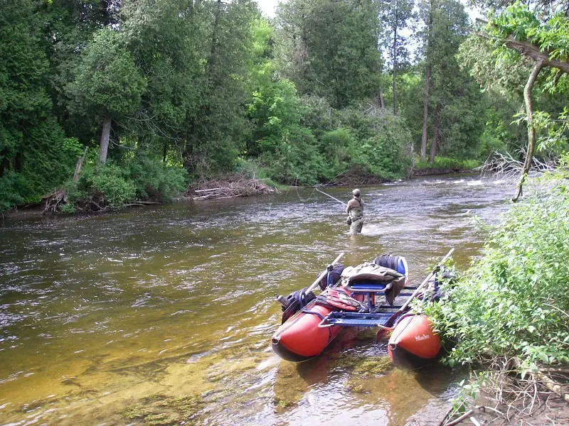 The authors smaller river fishing boat and his fishing buddy fly fishing.